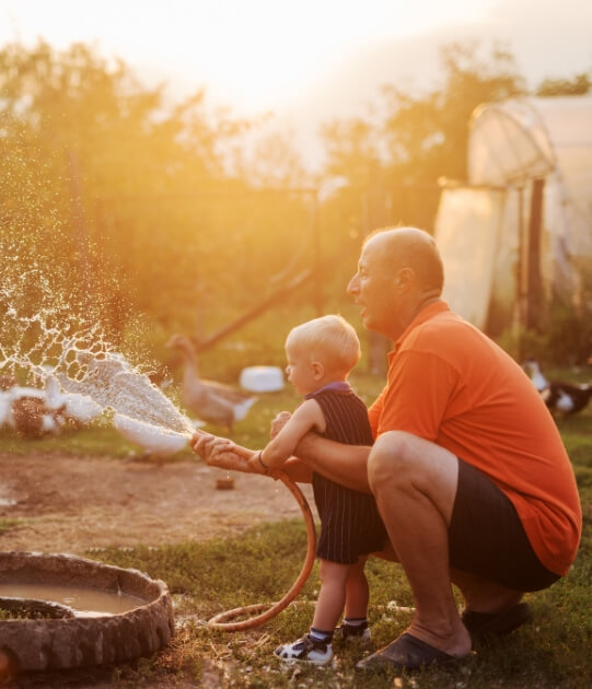 Father and son watering the yard